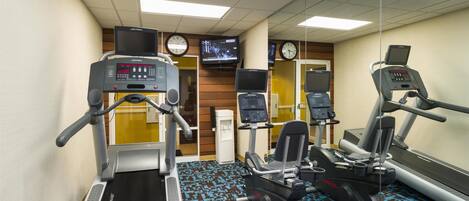 A gym with treadmills, elliptical machines, and weight machines.