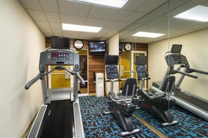 Un gimnasio con cintas de correr, elípticas y máquinas de pesas.