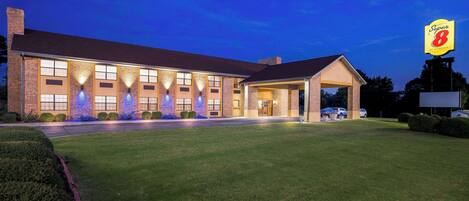 A hotel with a brick facade, multiple windows, and a covered entrance.