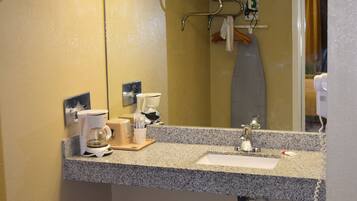 Un bany amb taulell de granit, un lavabo, un mirall i una barra de tovalloles.