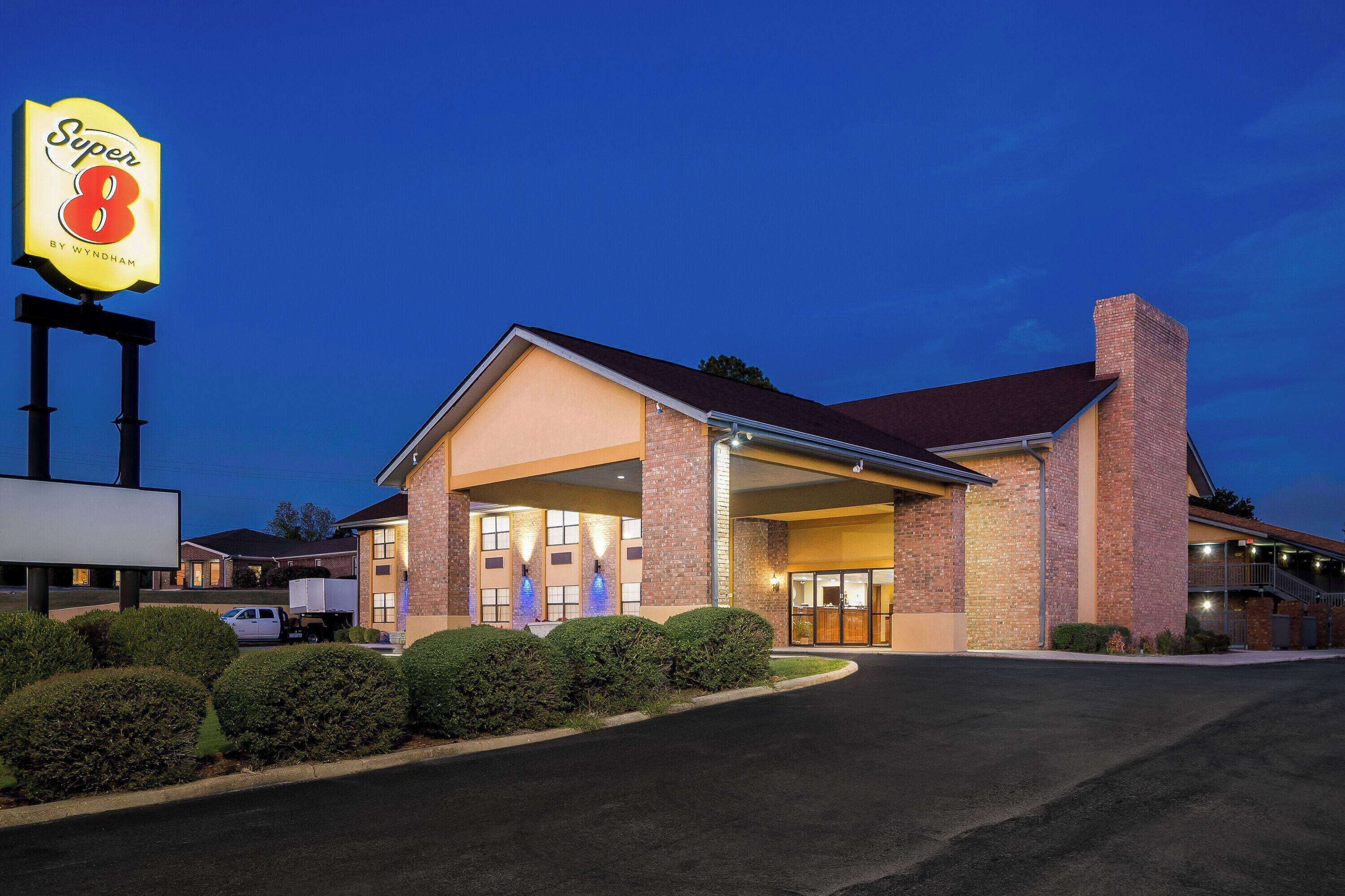 A hotel with a large sign reading "Super 8 by Wyndham" and a covered entrance.