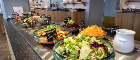A buffet with various salads and a pitcher of Thousand Island dressing.
