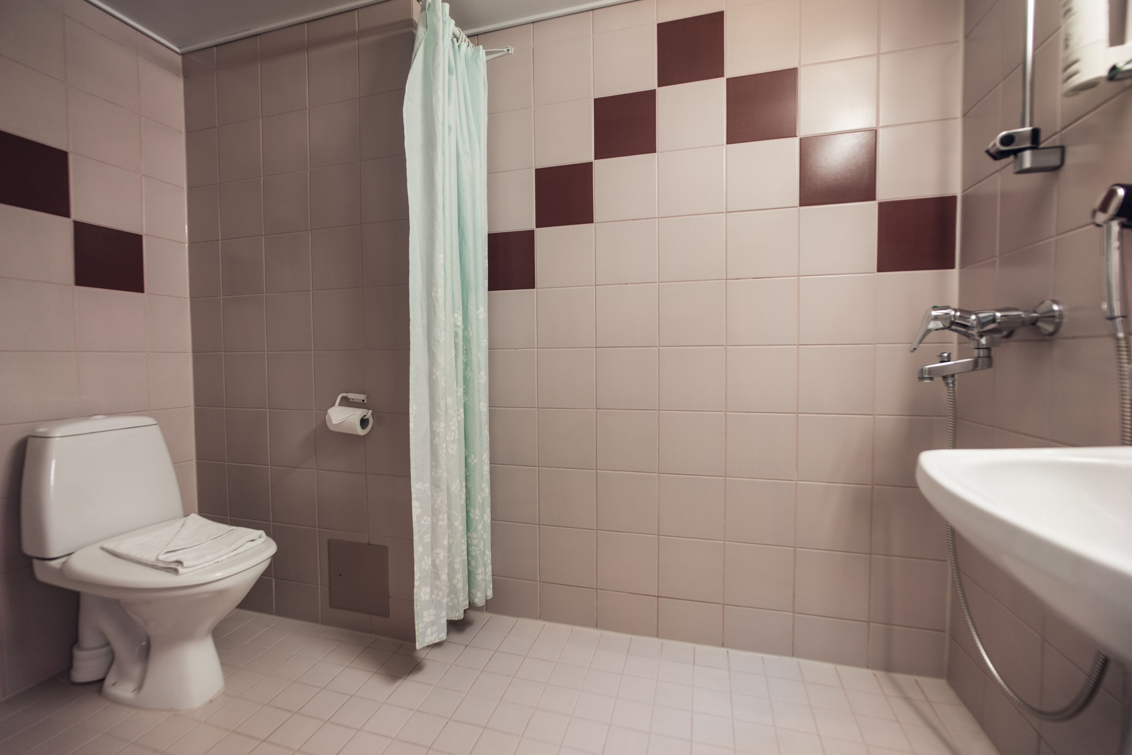 A bathroom with a toilet, shower, and sink.