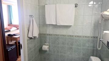 A bathroom with a shower, a toilet, and a towel rack.