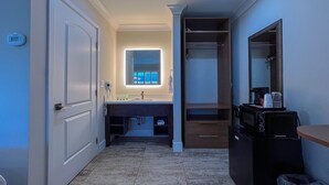 Une salle de bain moderne avec un meuble-lavabo, un évier, un miroir et un dressing.