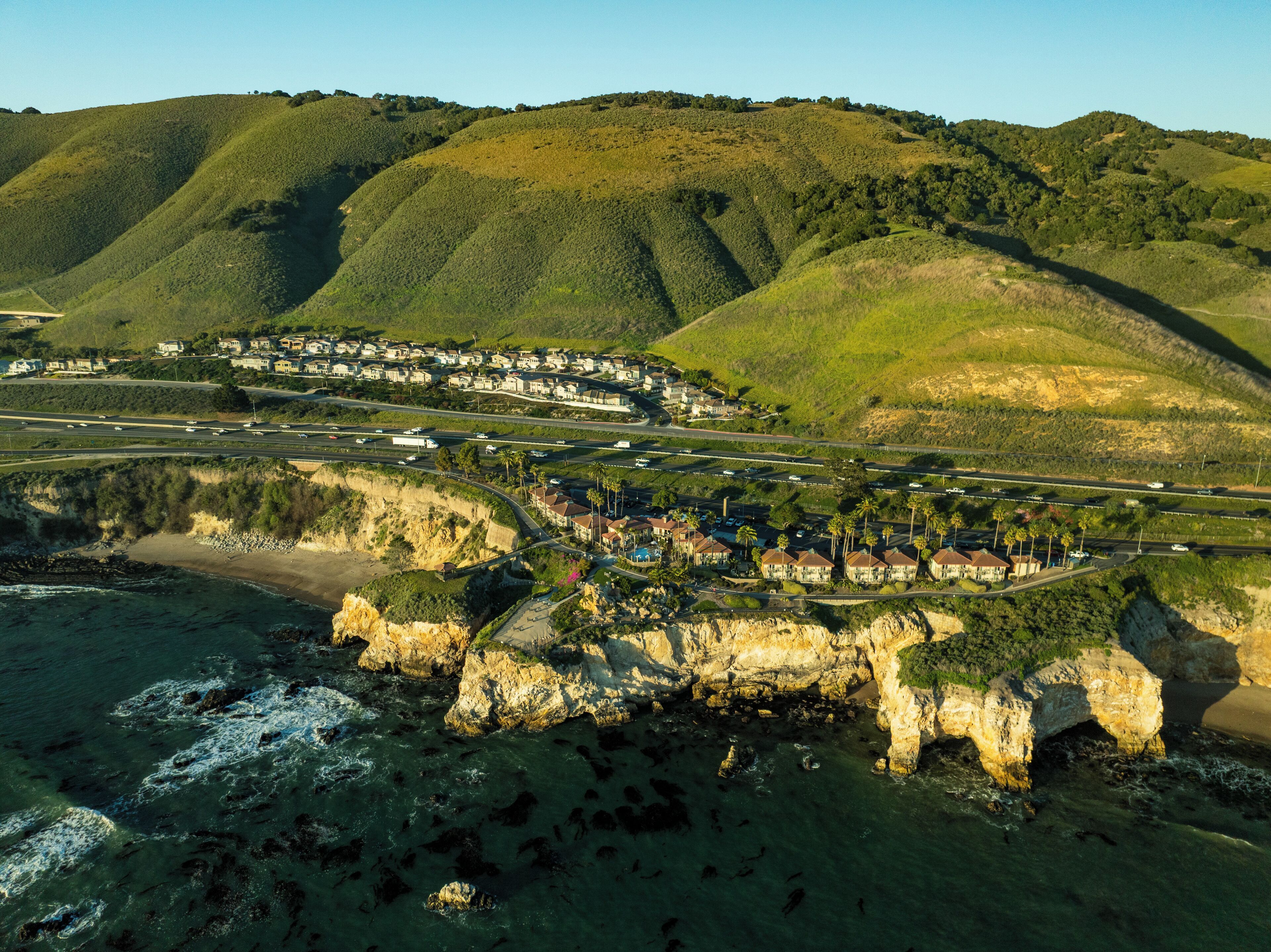 Une ville côtière avec des maisons construites le long de la falaise, une plage et une route menant au centre-ville.