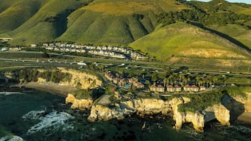 Un pueblo costero con casas a lo largo del acantilado, una playa y un camino que conduce al pueblo.