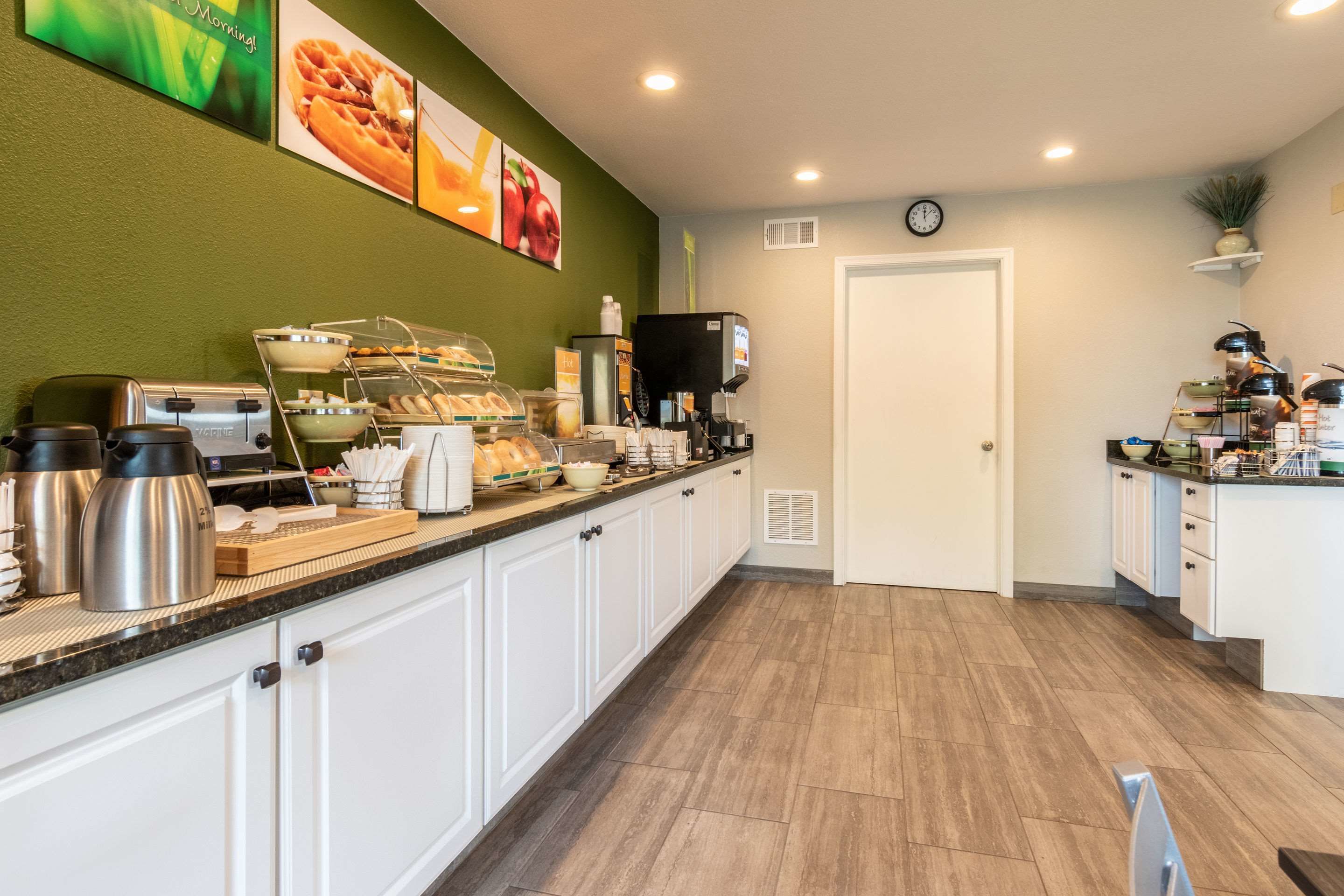 A modern kitchen with a coffee station, toaster, and various food items.
