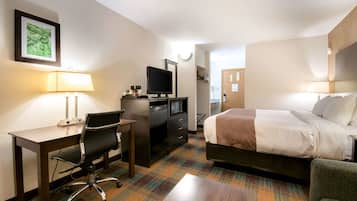 Ein Hotelzimmer mit Bett, Schreibtisch, Stuhl und Fernseher.