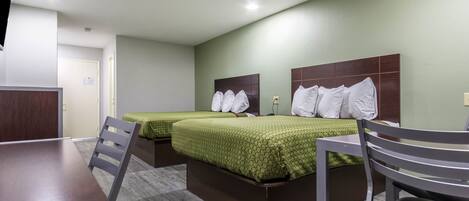 Una habitación de hotel con dos camas, un escritorio y una silla.