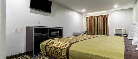 A hotel room with a bed, a television, a desk, and a wardrobe.