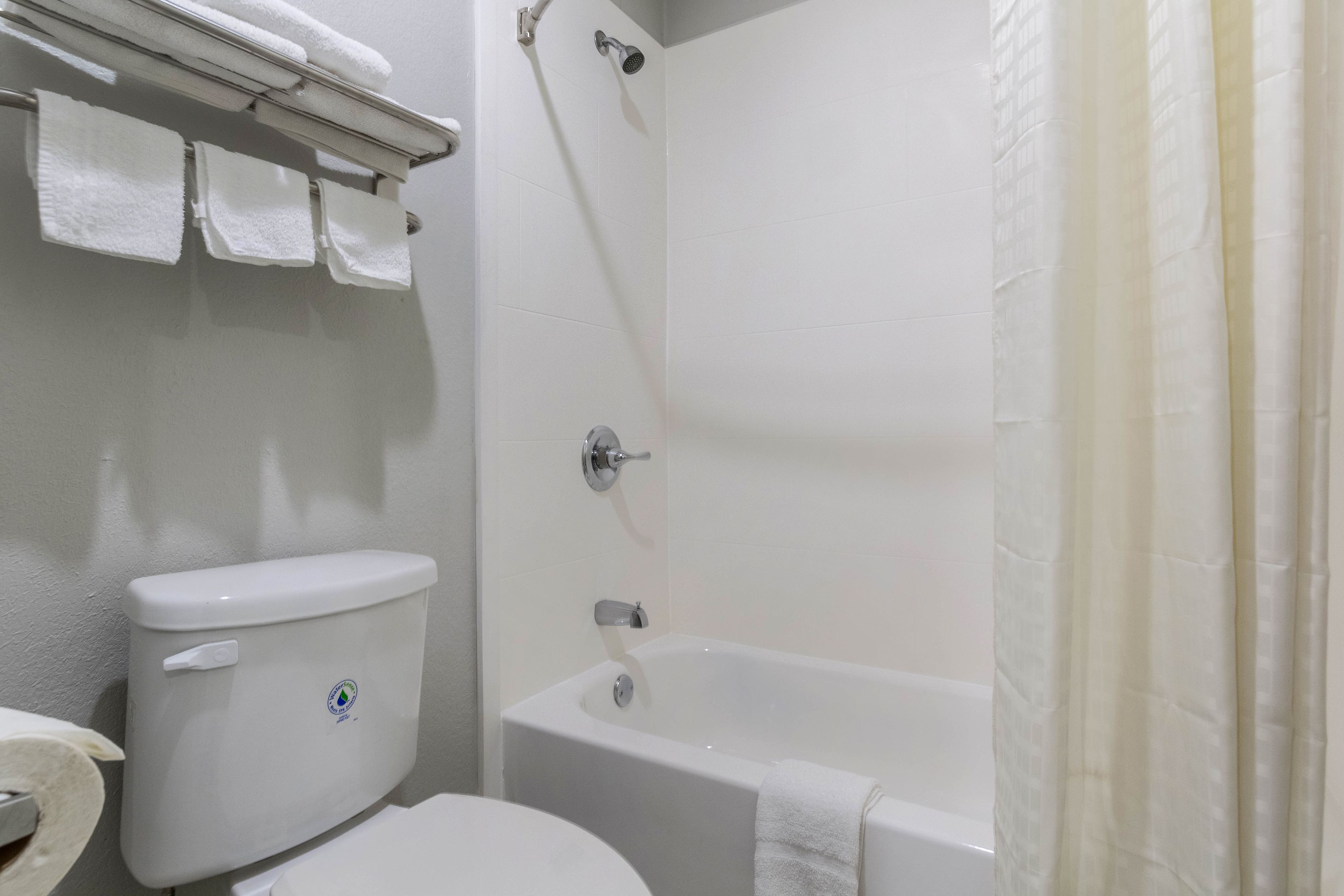 Ein Badezimmer mit Toilette, Badewanne und Duschvorhang.