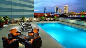 A rooftop pool area with outdoor seating and a view of the city skyline. - Marriott Jacksonville Downtown (Jacksonville)