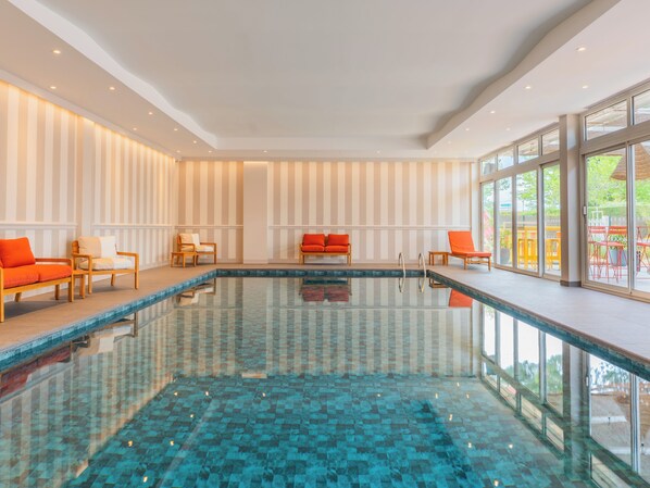 A swimming pool with chairs and a view of the outdoors.