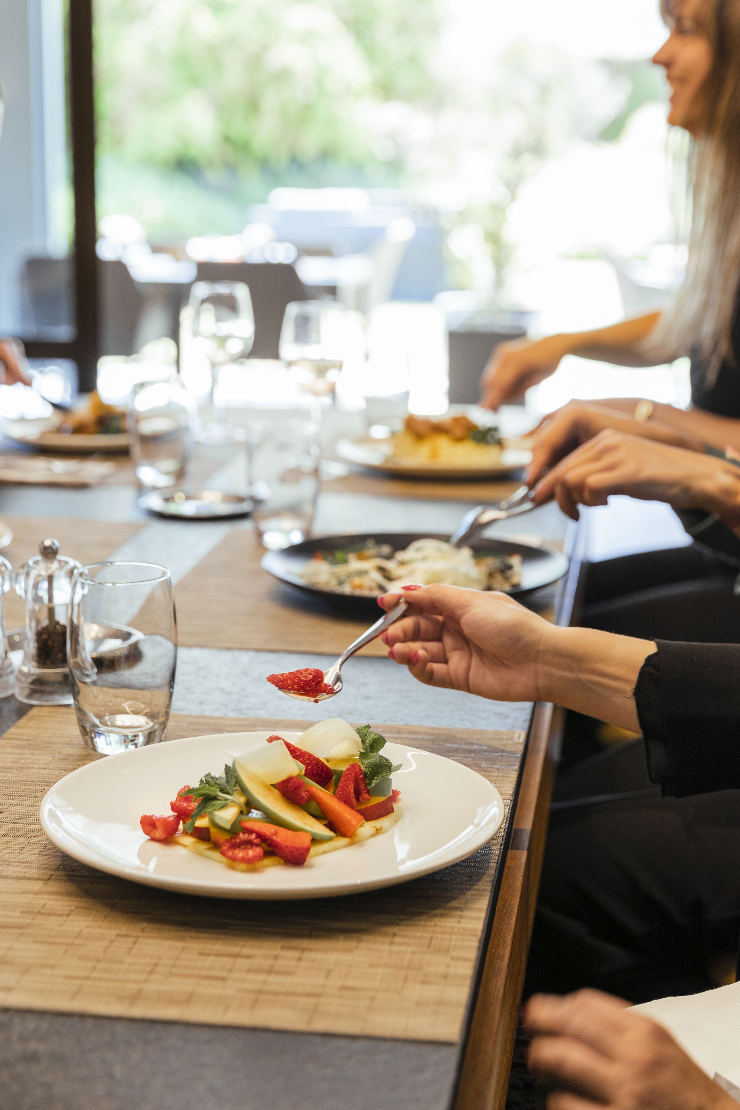 A dining table with plates of food, glasses, and a pitcher.