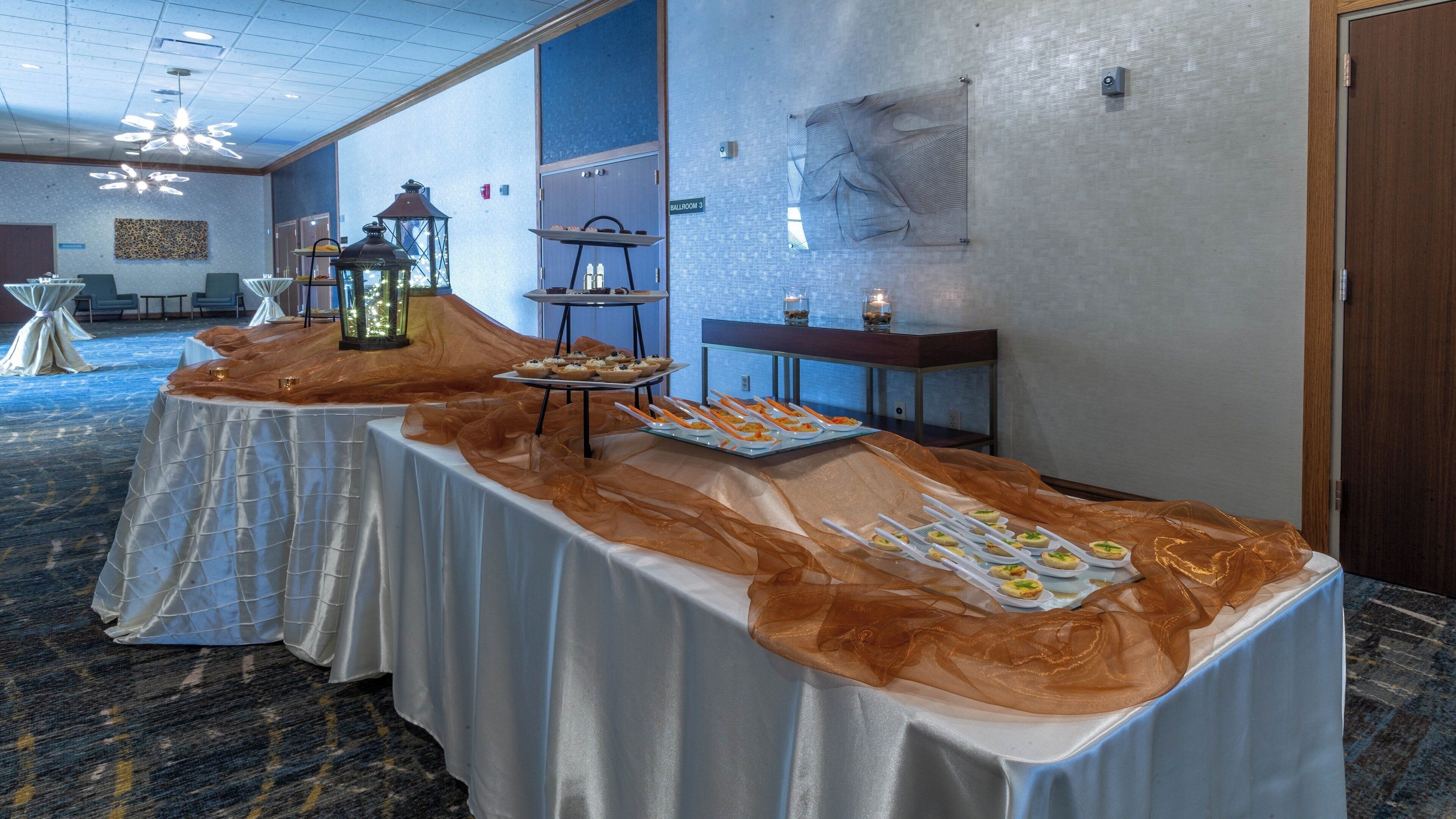 A buffet table with food items and a lantern in a hotel room.