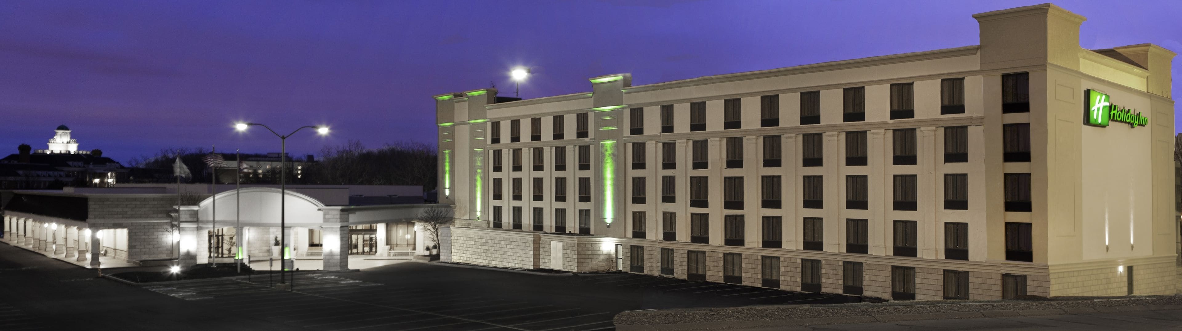A Holiday Inn hotel with a modern facade, multiple floors, and a parking lot.