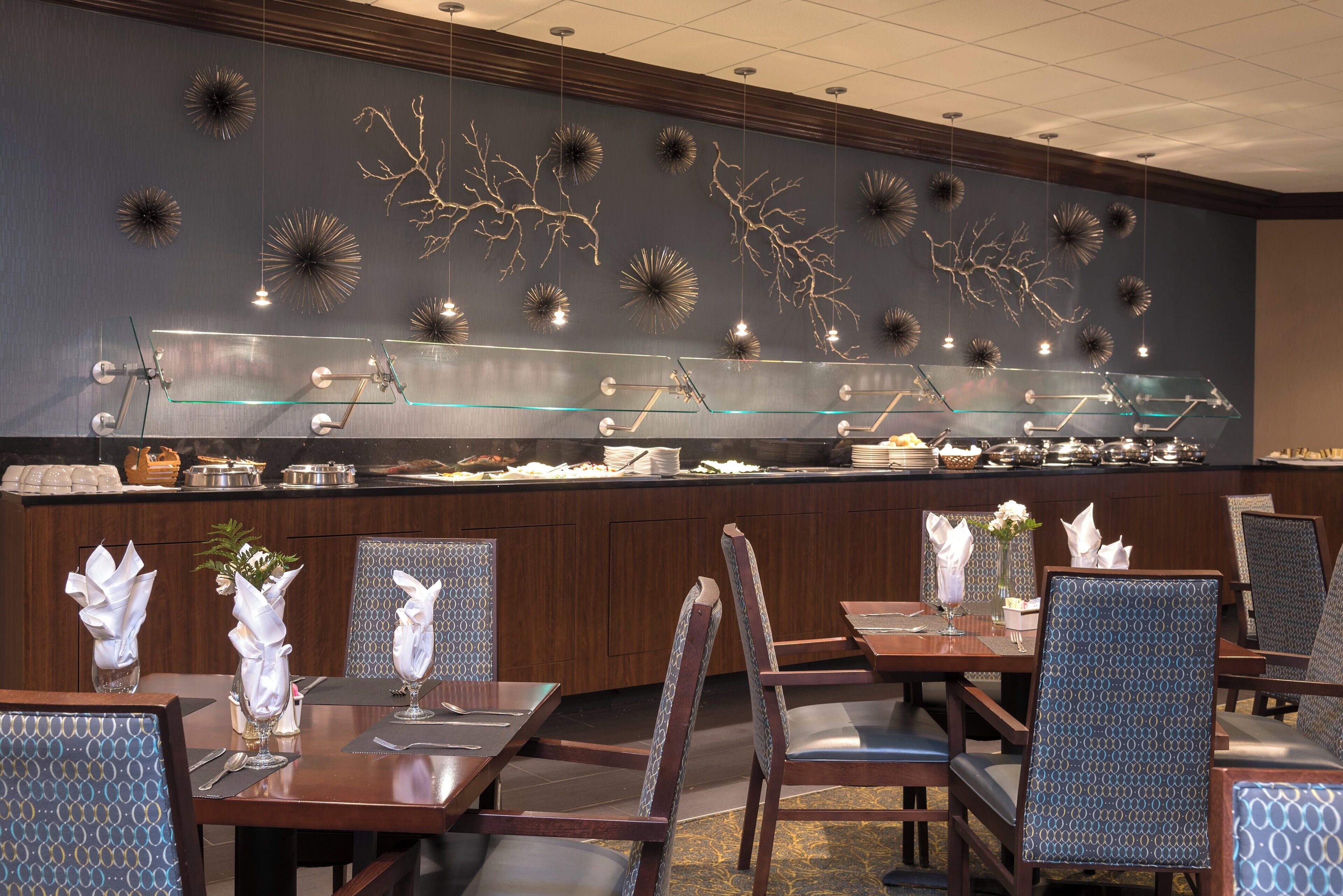 Un comedor de hotel con barra libre, que incluye una vitrina de vidrio y una variedad de alimentos.