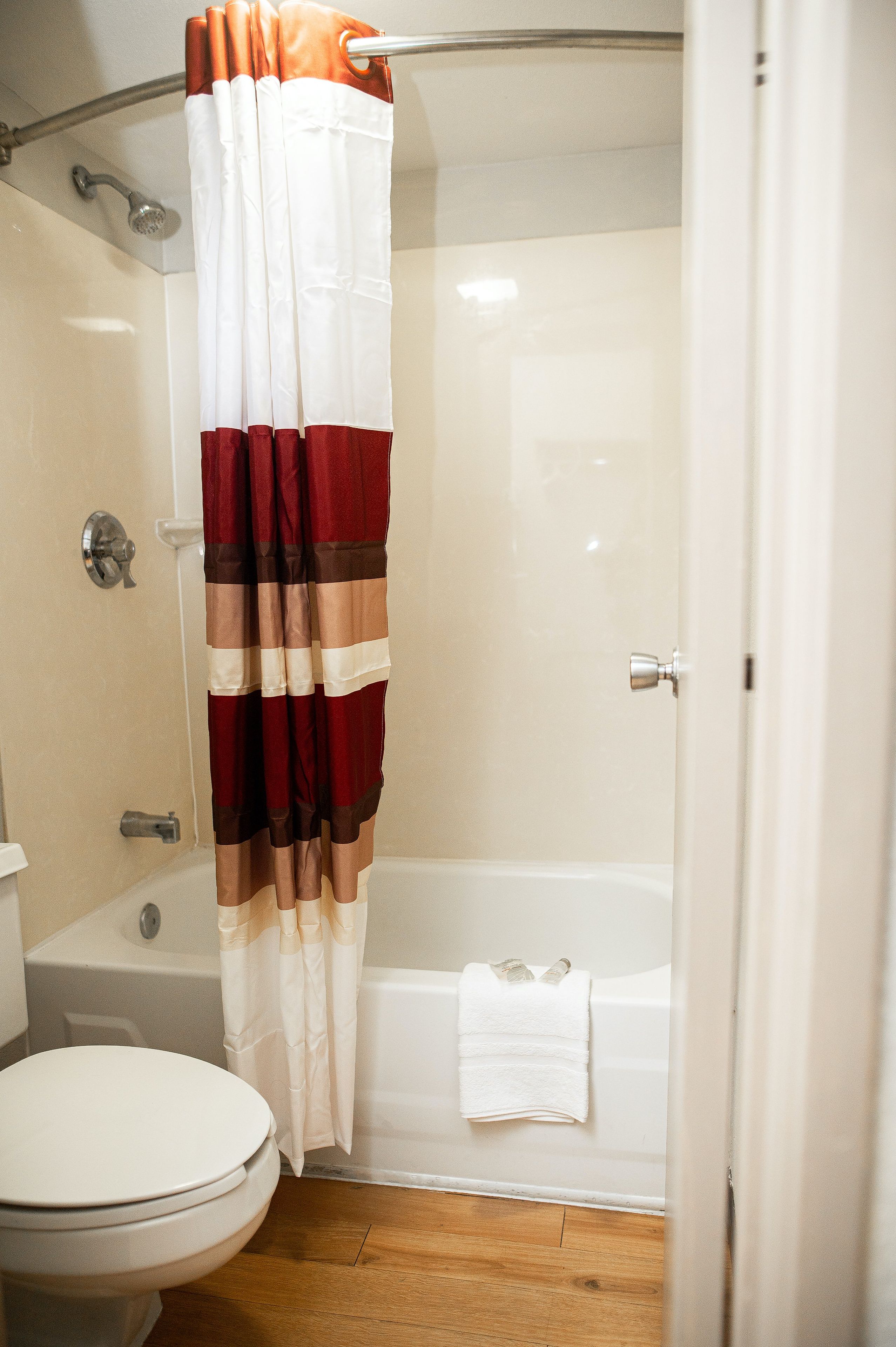 A bathroom with a shower curtain, a toilet, and a bathtub.