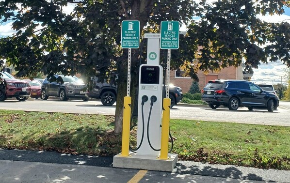 An electric vehicle charging station with two signs indicating it is for electric vehicles only.
