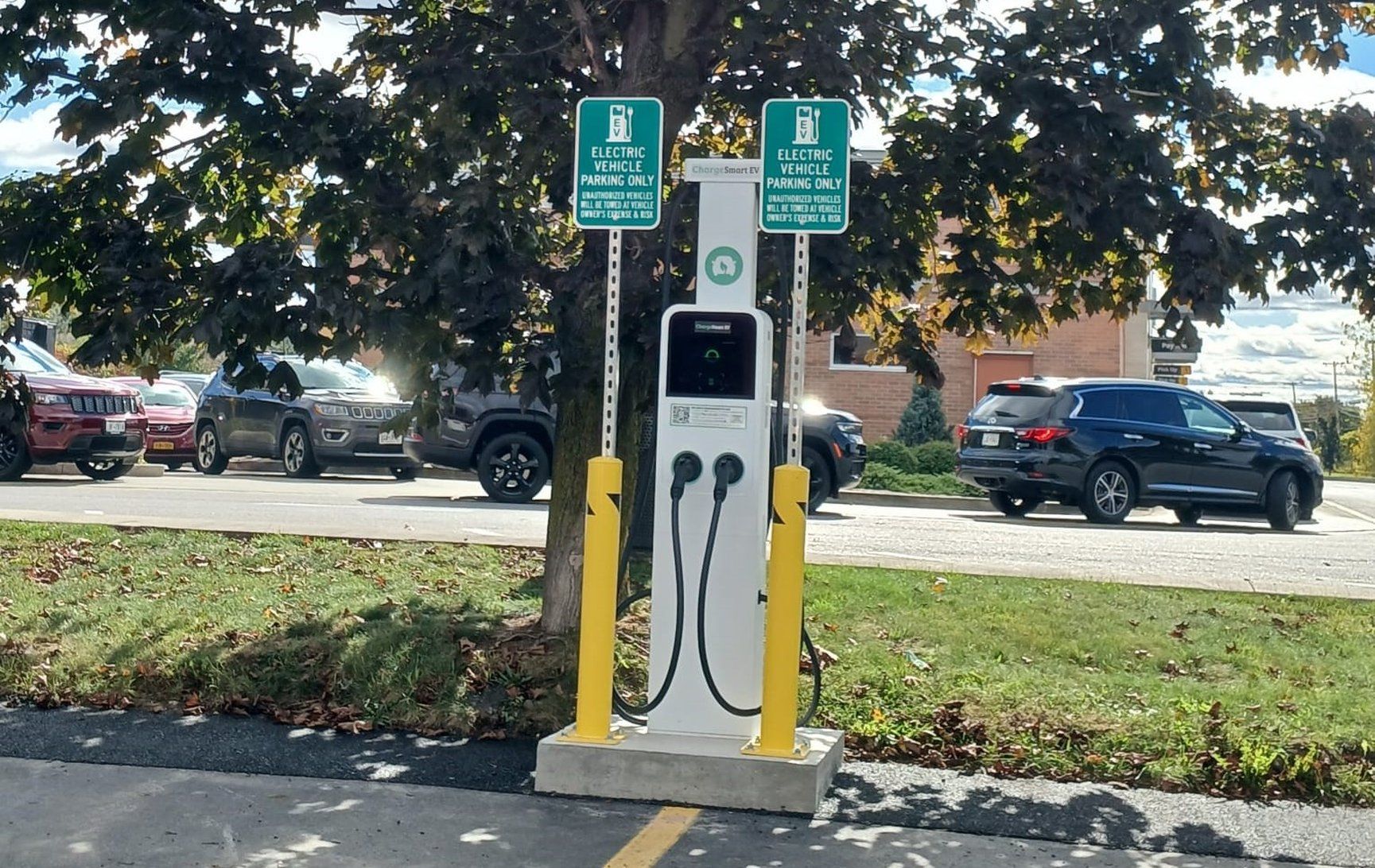 An electric vehicle charging station with two signs indicating it is for electric vehicles only.