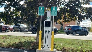 An electric vehicle charging station with two signs indicating it is for electric vehicles only.
