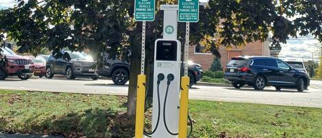 An electric vehicle charging station with two signs indicating it is for electric vehicles only.