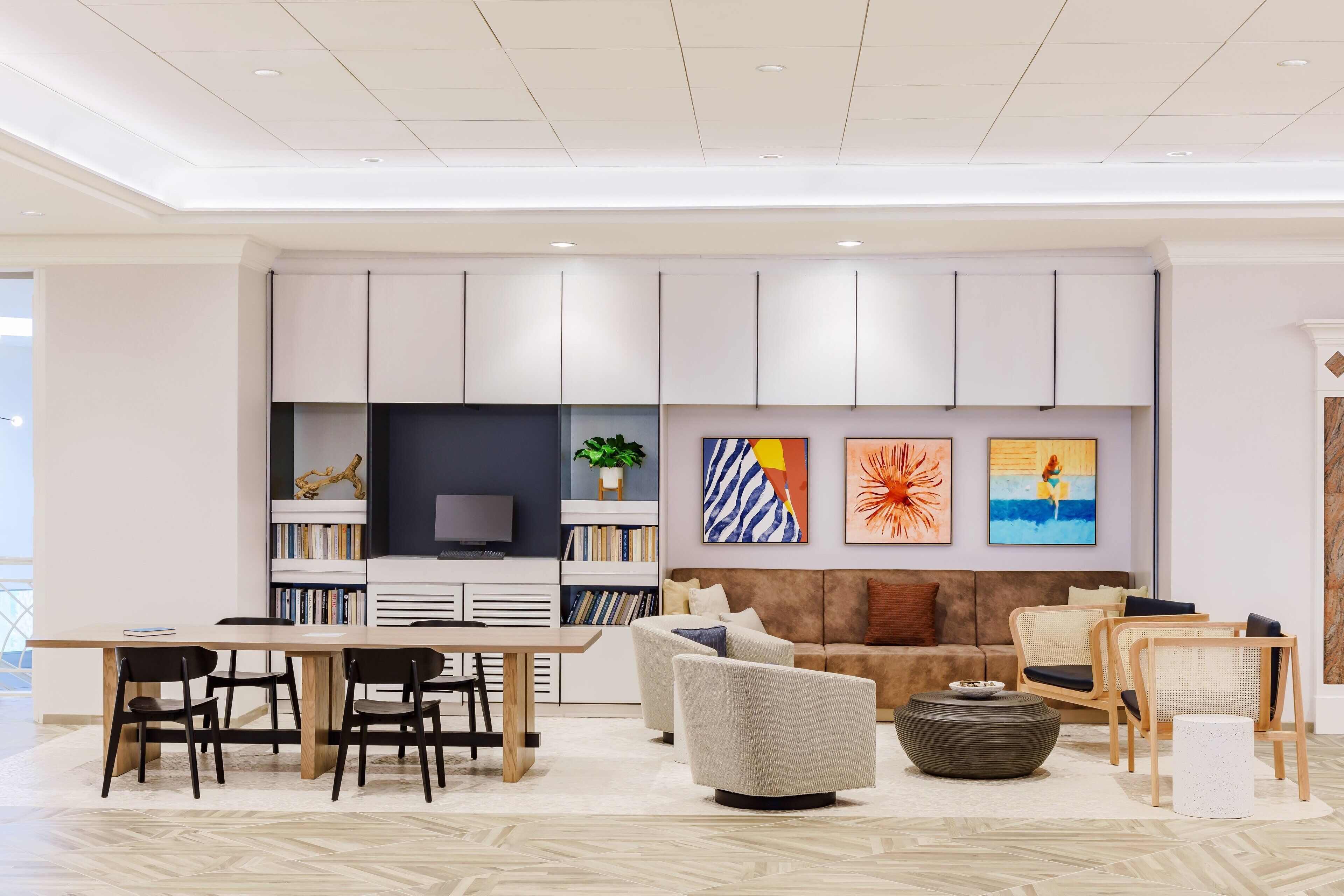 A modern living room with a dining area, a sofa set, and a flat-screen TV.