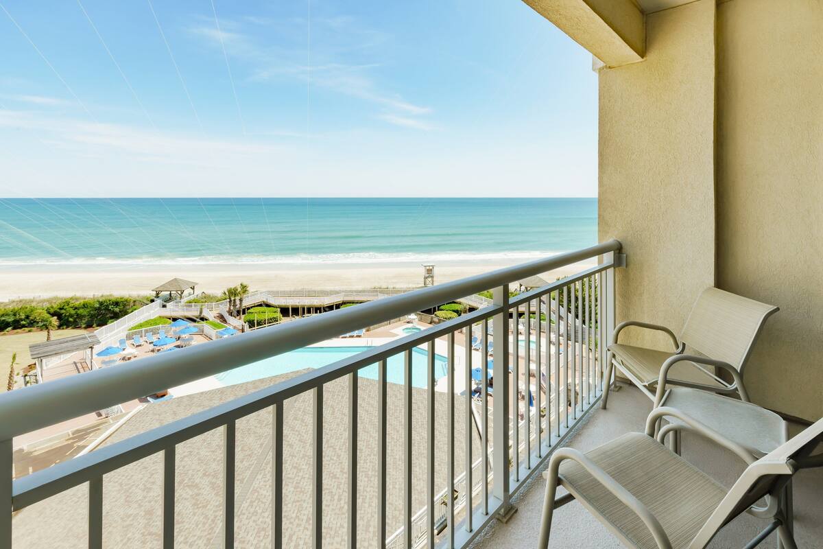 Ein Balkon mit Blick auf Strand und Poolbereich.