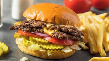 Una hamburguesa acompañada de papas fritas.