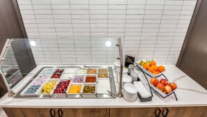 A buffet with various food options and a sign for the Custom Creation Bar.