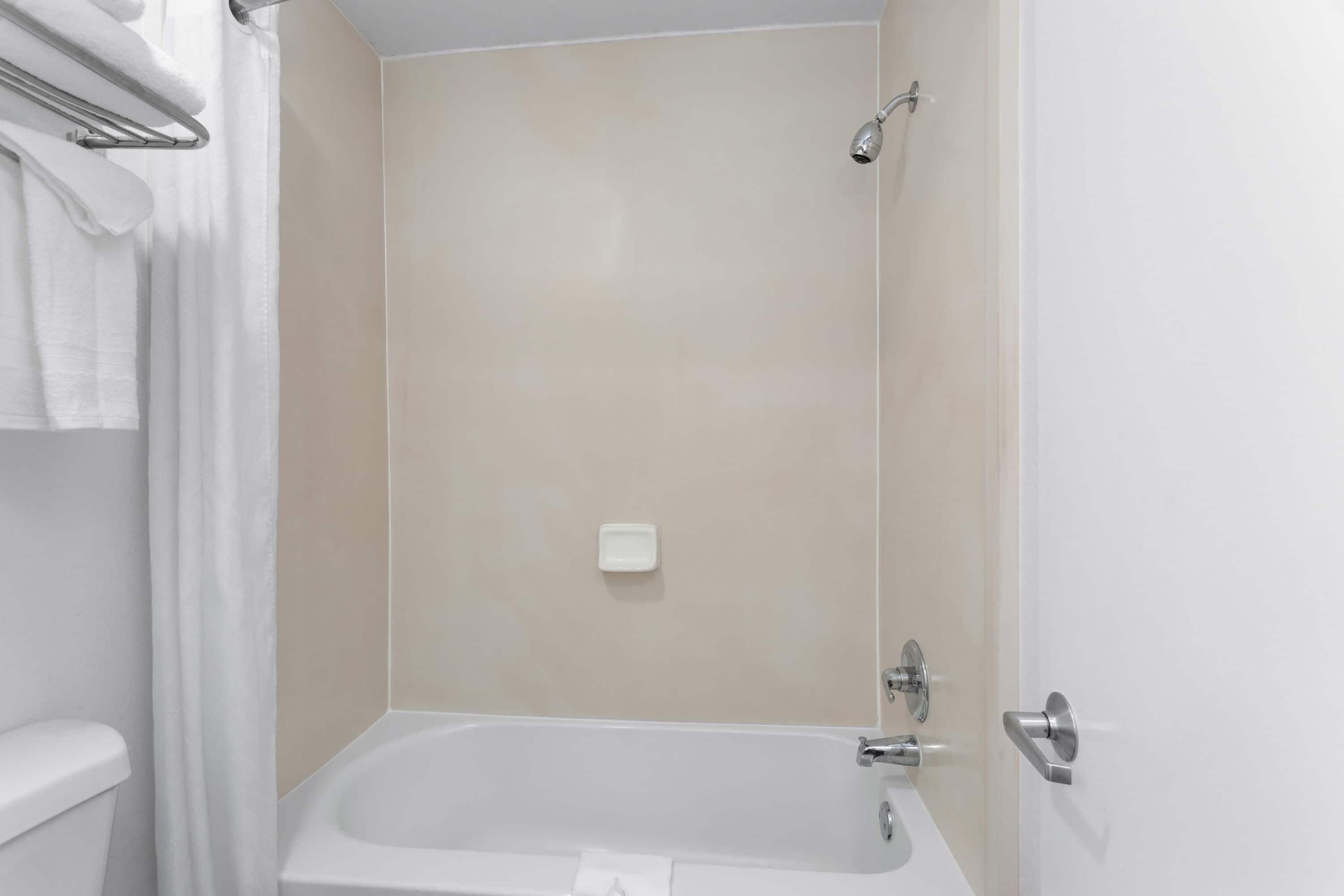 A bathroom with a bathtub, a toilet, and a shower.