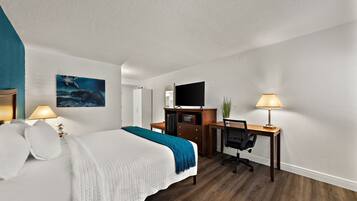 Une chambre d’hôtel avec un lit, un bureau et une télévision.