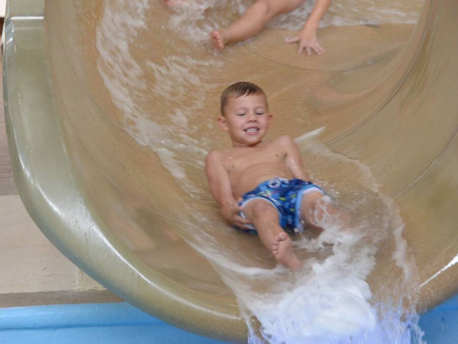 Un tobogán de agua con dos niños abajo.