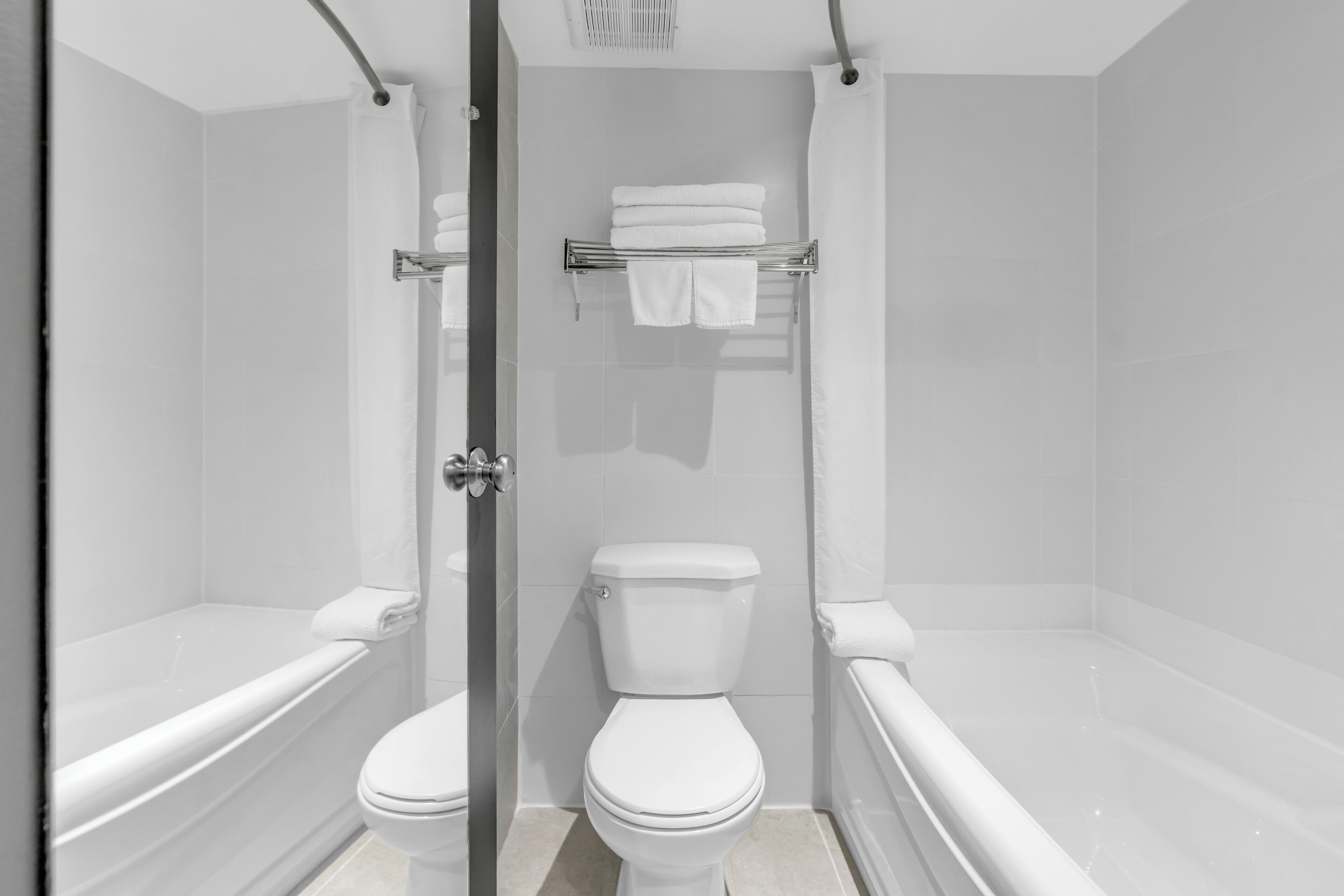 Un baño moderno con ducha de vidrio, inodoro blanco y bañera.