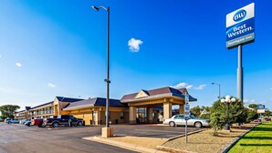 Un Best Western Northgate Inn con aparcamiento, un edificio de techo marrón y un cielo azul despejado.