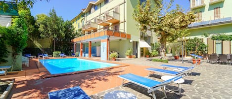 Una piscina al aire libre de temporada, sillones reclinables de piscina