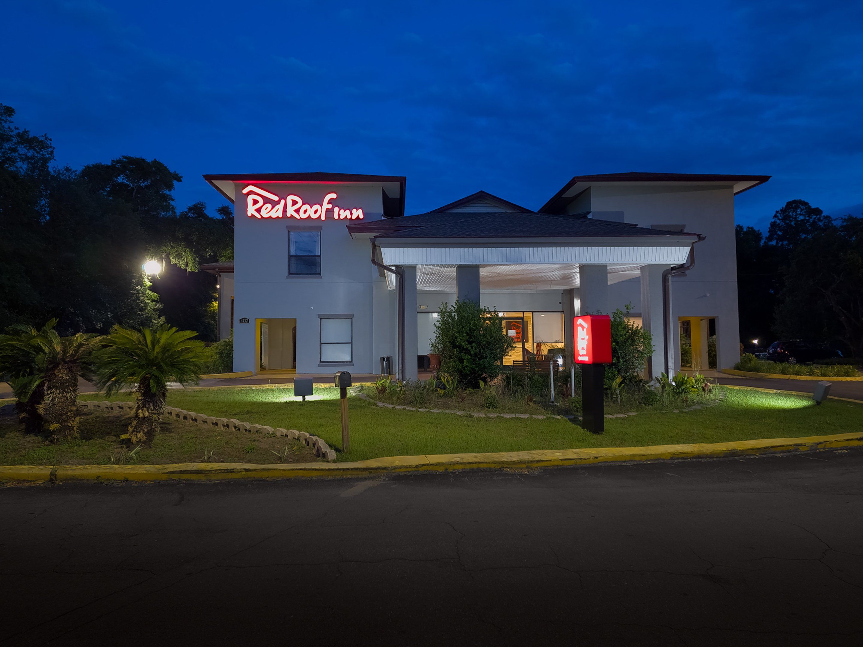 A two-story building with a sign that reads 'Red Roof Inn.'
