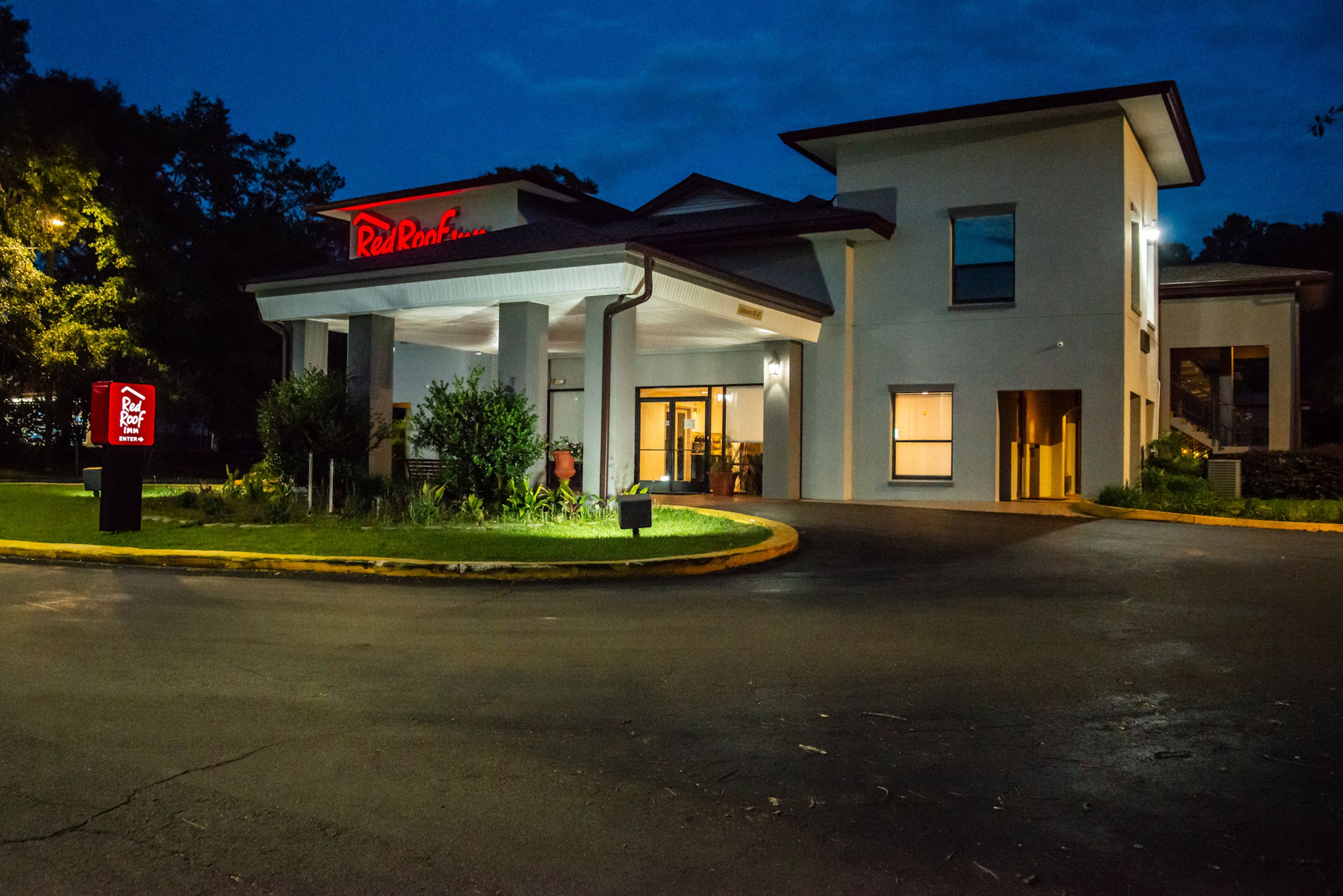 Un hôtel Red Roof Inn doté d’une entrée abritée et d’une façade bien éclairée.