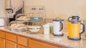 A breakfast bar with cereal, a coffee maker, a kettle, and a fruit punch dispenser. - Econo Lodge Inn & Suites Lodi - Wine Country Area (Lodi)