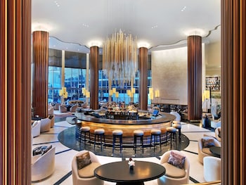 A balcony table with breakfast items, a bottle of champagne, and a view of the ocean. at Eden Roc Miami Beach