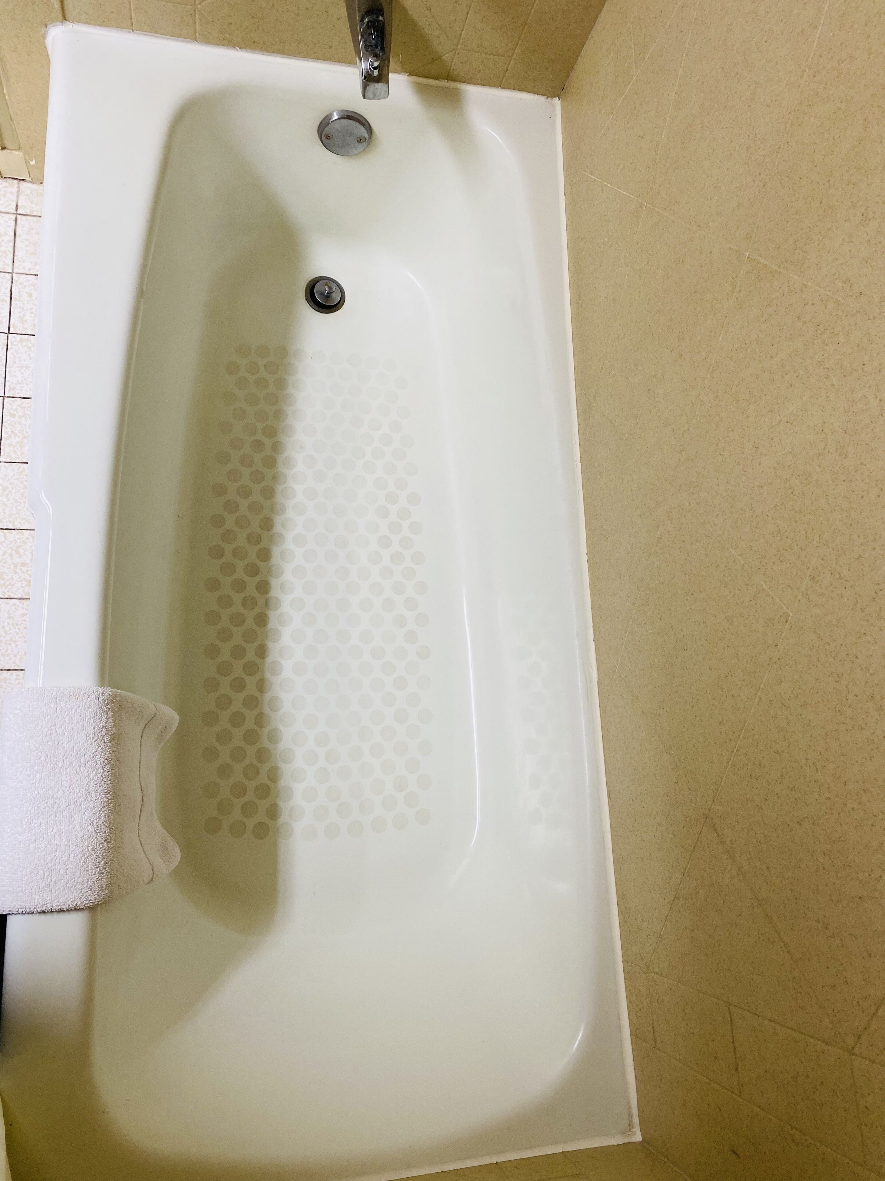 A white bathtub with a faucet and a drainage hole.