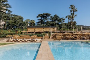 Una piscina al aire libre de temporada, camas de piscina con cargo