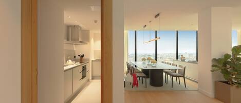 A modern kitchen with white cabinets and a dining area with a large table and chairs.