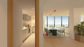 Una cocina moderna con armarios blancos y un comedor con una mesa grande y sillas.