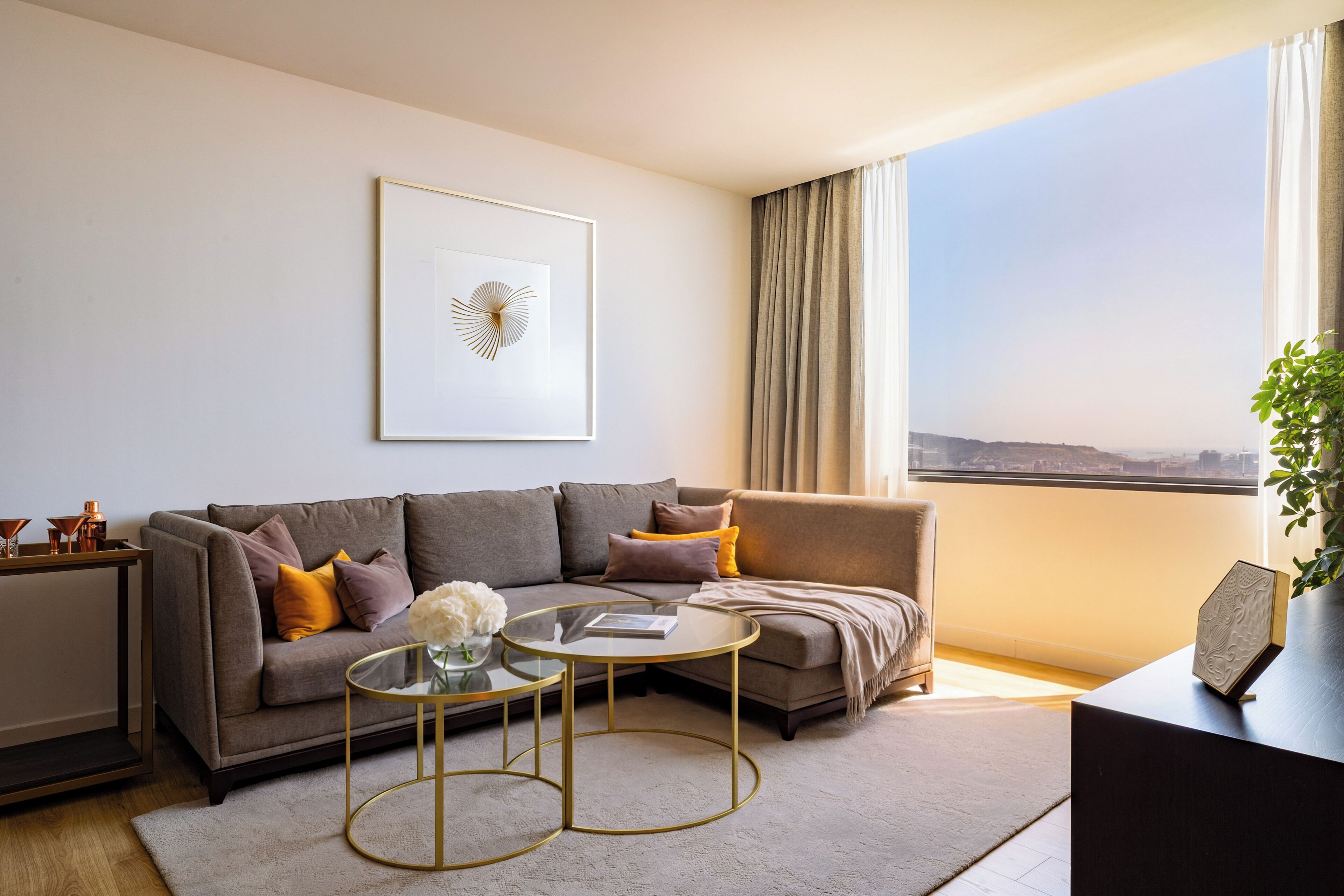 Una sala de estar moderna con un sofá, una mesa de centro y vistas de la ciudad.