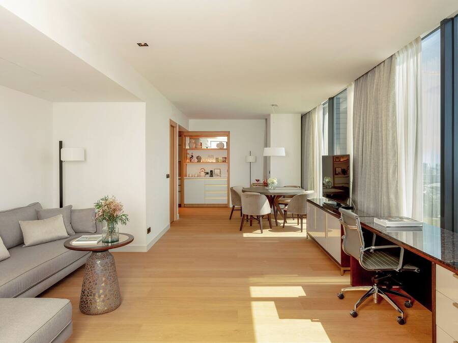Un salon moderne comprenant un canapé, une table basse et un coin repas avec des chaises et une table.