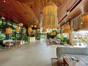 Relax in a serene space with comfortable seating, ambient lighting, and views of lush greenery.