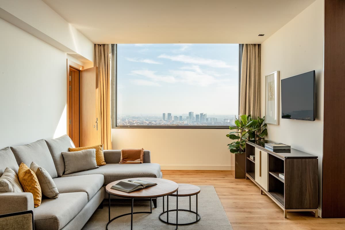 Una sala de estar moderna con un sofá, una mesa de centro y un televisor en la pared.