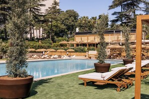 Relax by the serene pool surrounded by lush greenery and trees.